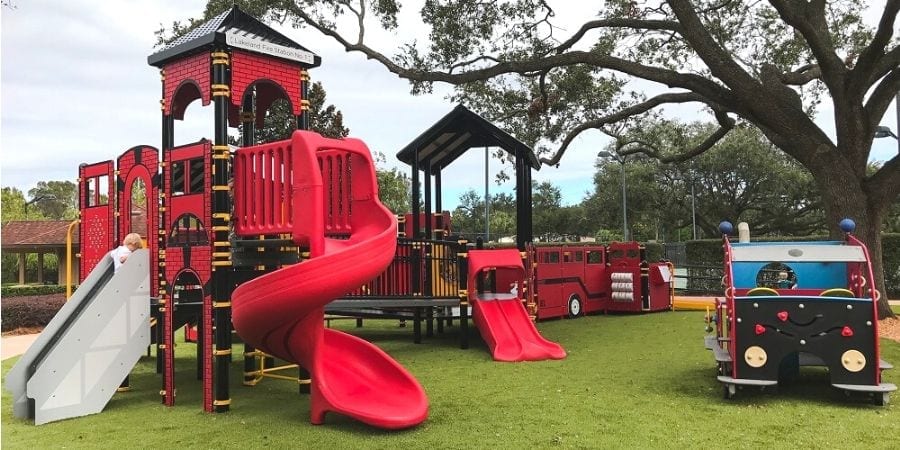 Children Playing On Playground In City Park Engaged In Football